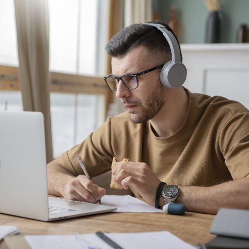 young-man-studying-library-using-laptop-min